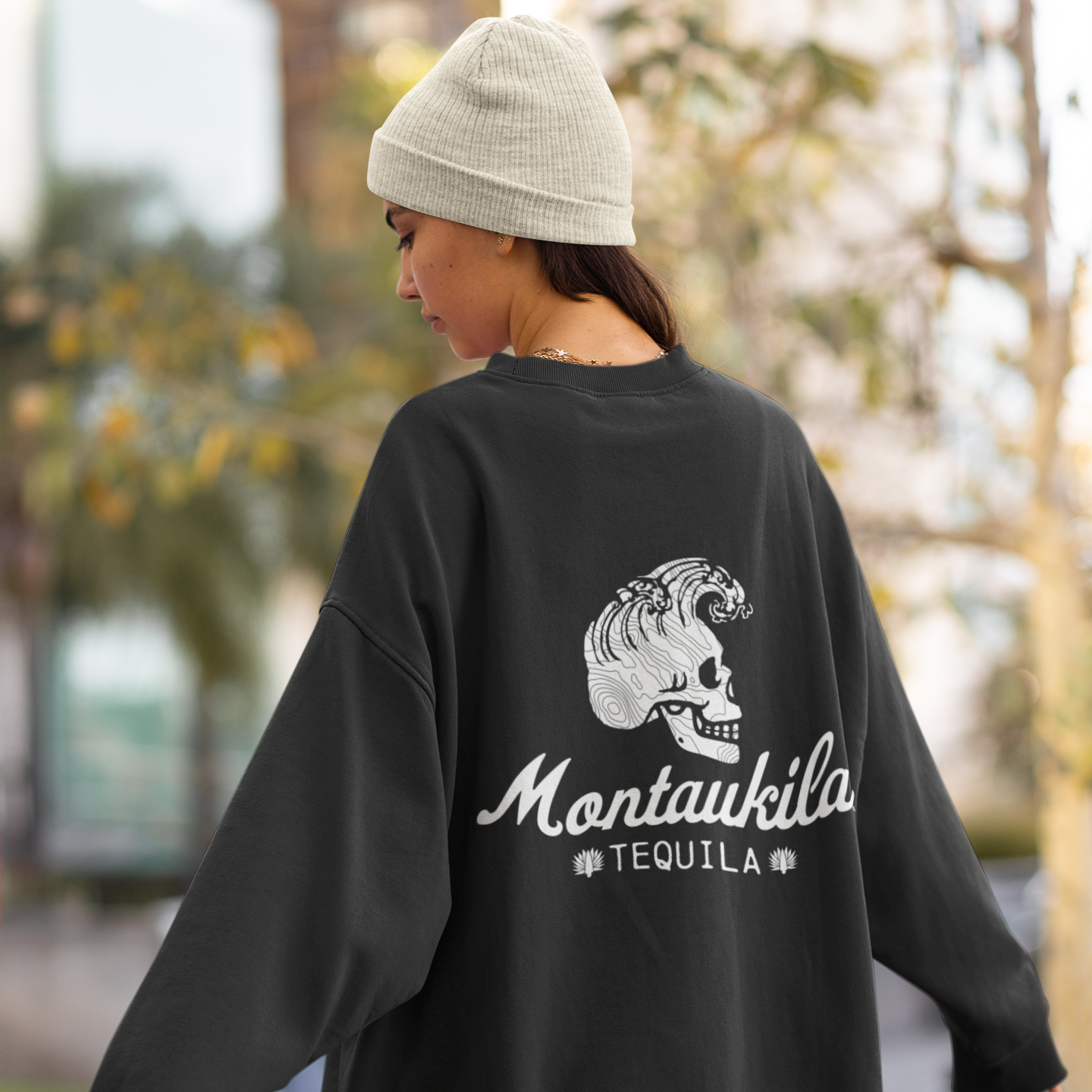 Person wearing a black sweatshirt with a montaukila logo outdoors